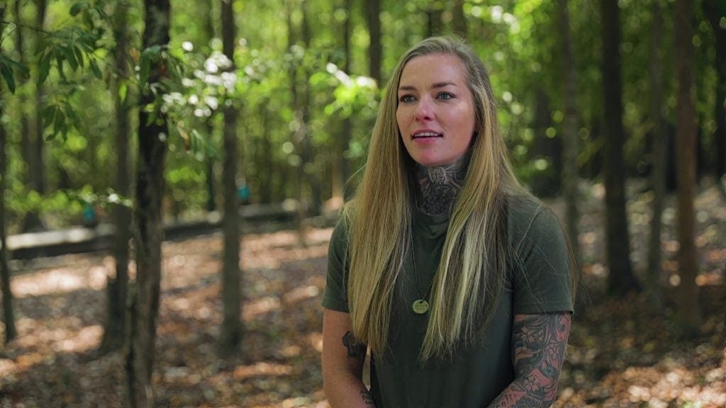 A woman with tattoos in a historical fiction setting.